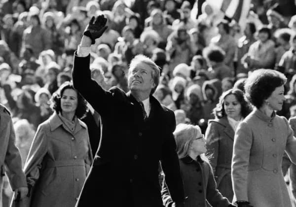 President Jimmy Carter waves to the crowd while walking with his wife Rosalynn and their daughter Amy along Pennsylvania Avenue from the Capitol to the White House following his inauguration on Jan. 20, 1977, in Washington, D.C.