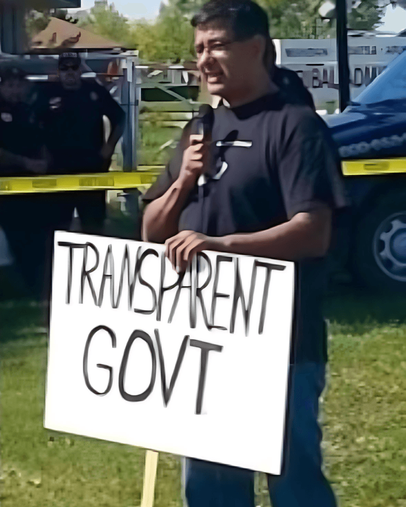 In 2014, Mark Fox holds a tribal government transparency sign as he campaigns outside the Mandan, Hidatsa and Arikara Nation tribal administration building in New Town, North Dakota. It was his first tribal chairman campaign.