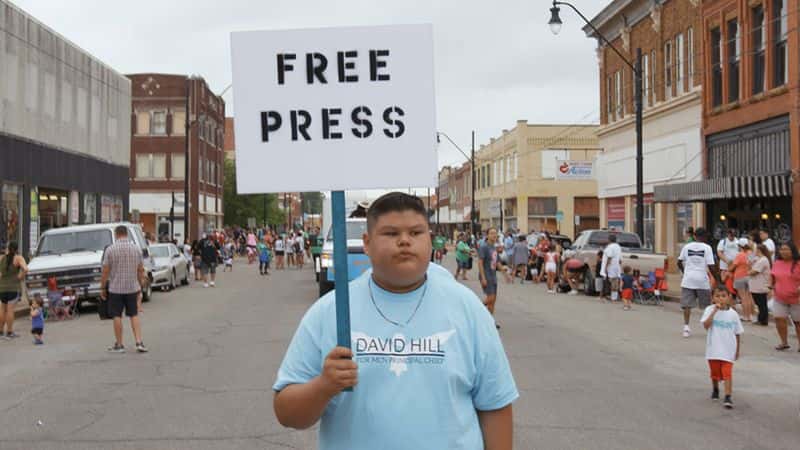 A young person holds a sign that reads “Free Press” while walking in a parade captured in the documentary "Bad Press." (Photo courtesy of "Bad Press")
