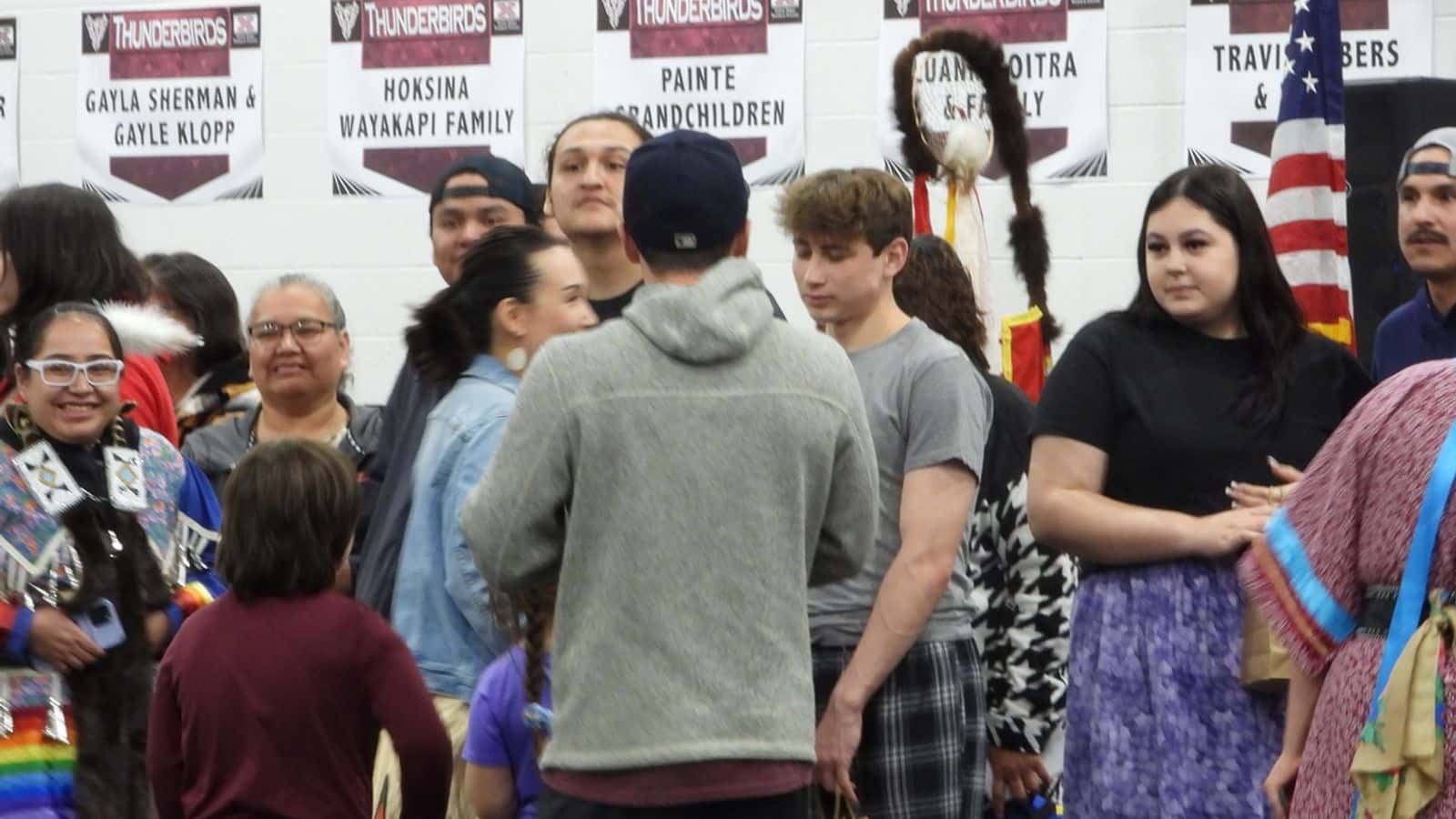 High school seniors Hunter Spotted Bear, center, and Tenleigh DeLorme, right, join Bismarck-Mandan high school and Monarch program high shcool students during an April 27 powwwow on he United Tribes Technical College campus. Powwow organizers celebrated all area graduating college and high school senior 2024 May graduations (Photo Credit, Jodi Rave Spotted Bear).