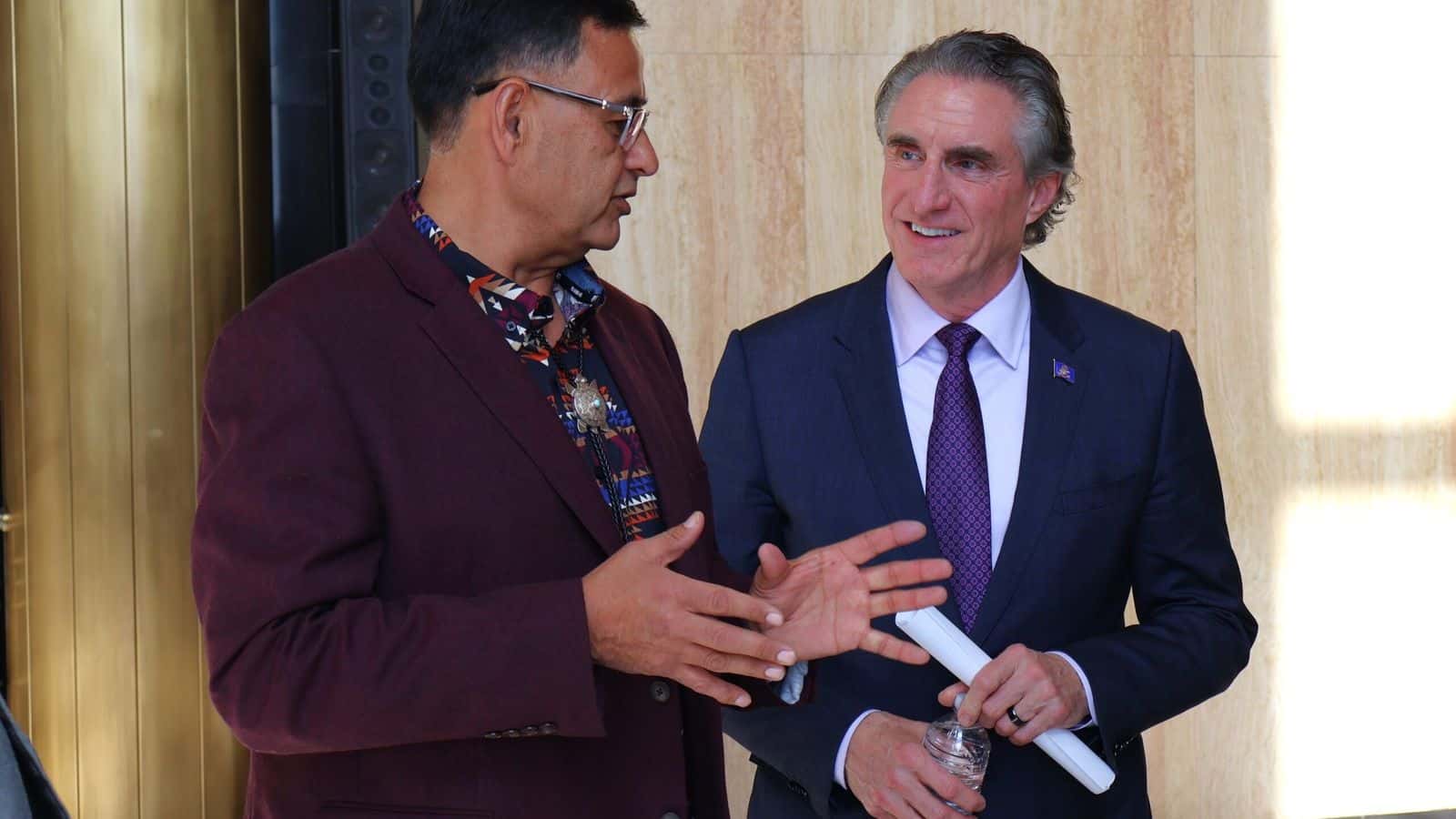 Mandan, Hidatsa and Arikara Nation Chair Mark Fox, left, speaks with North Dakota Gov. Doug Burgum in Memorial Hall during a signing event for an alcohol tax revenue sharing agreement between the state and the MHA Nation on March 22, 2024. (Michael Achterling/North Dakota Monitor)