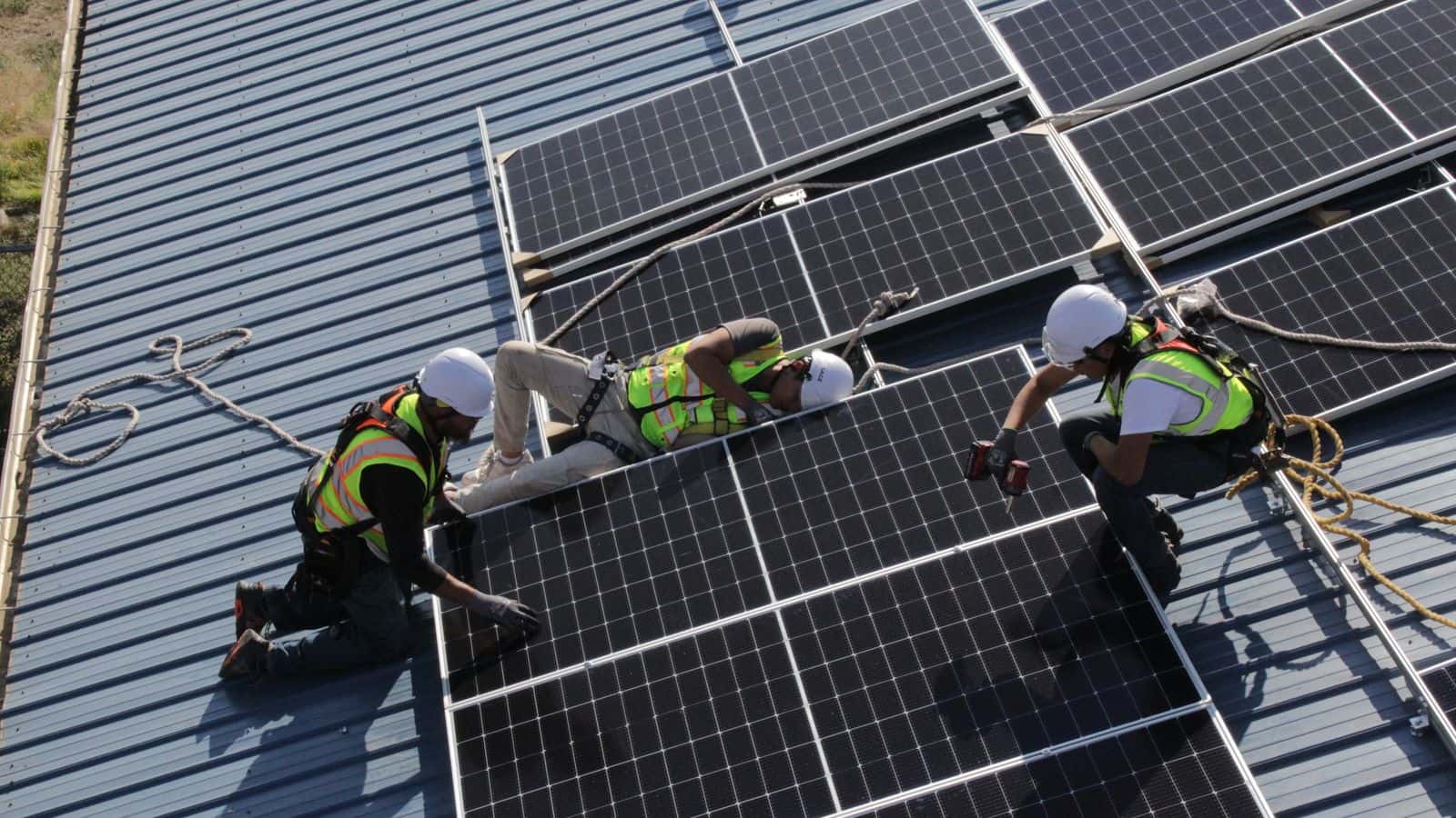 Lightspring Solar apprentices install solar panels on the roof of a community building in the small township of Wakpala, on the Standing Rock Reservation. (Photo credit/ Grace Fiori)
