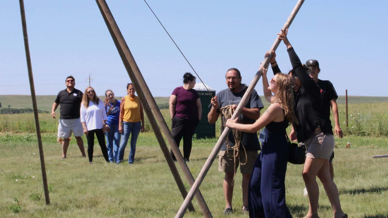 MMIP reporter, Jolan Kruse, joins members from the Standing Rock Sioux Tribe’s Child Support Enforcement Agency as they learn to raise a tipi in Cannon Ball, North Dakota, July 24. (Photo credit: Gabrielle Nelson)