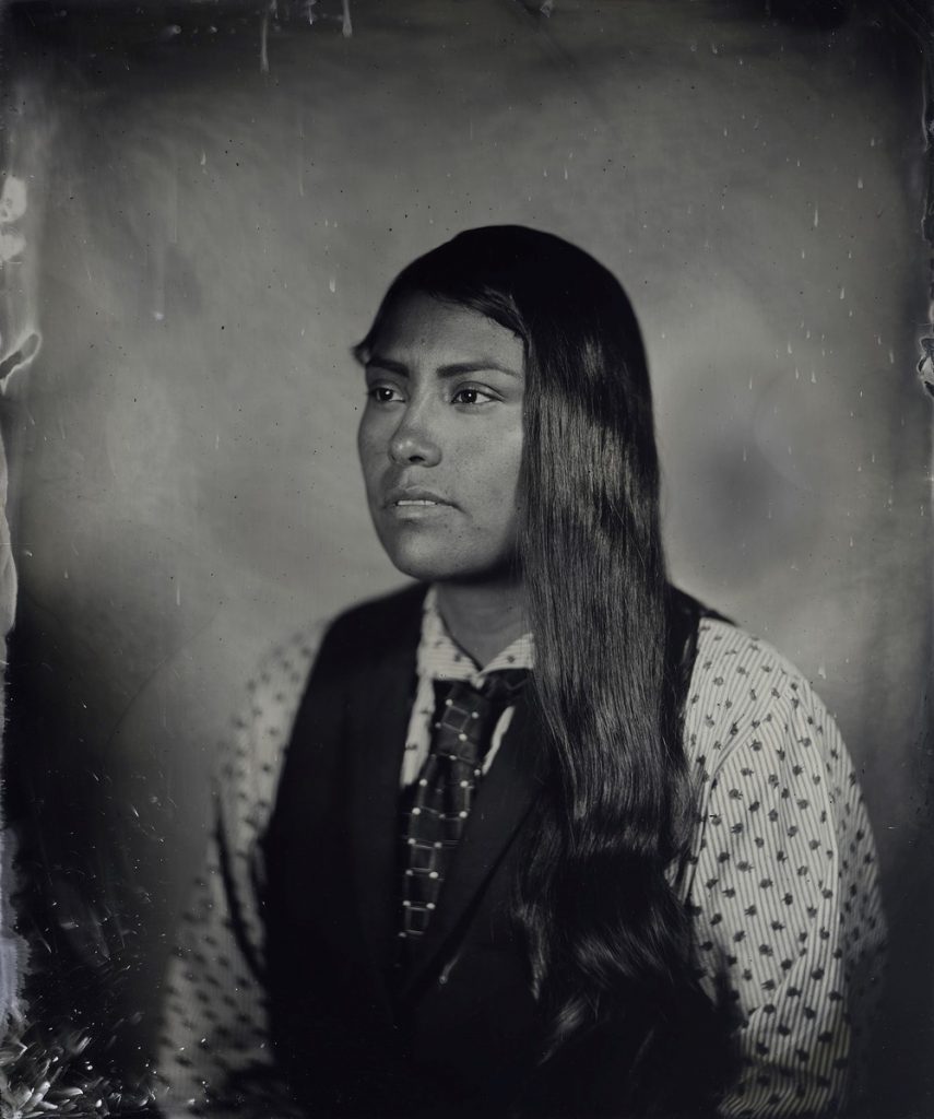 Kali Spitzer sepia tone portrait first nations indigenous woman wearing button down shirt and tie with long hair