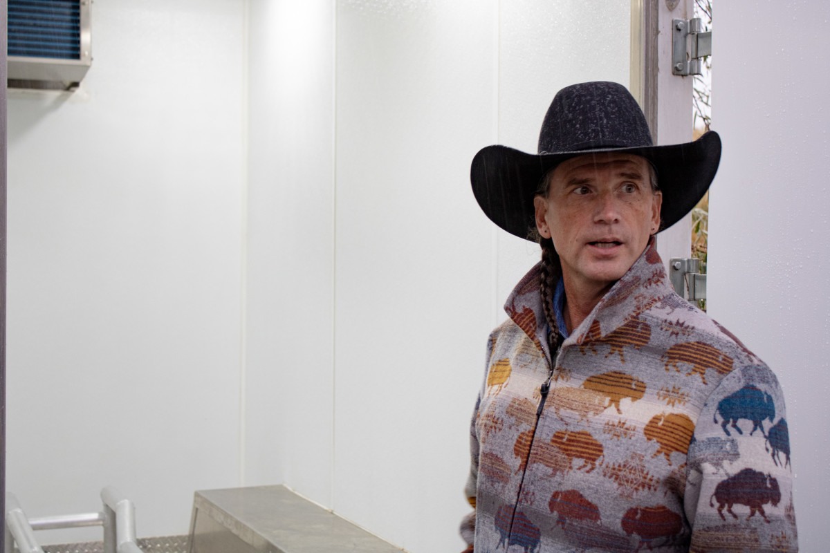 Troy Heinert, executive director of the InterTribal Buffalo Council, tours the mobile processing unit. Bison are killed and quartered prior to being loaded into the trailer for transport. (Photo by Amelia Schafer, ICT and Rapid City Journal)