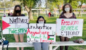 Community members with signs in support of prayers for Palestine