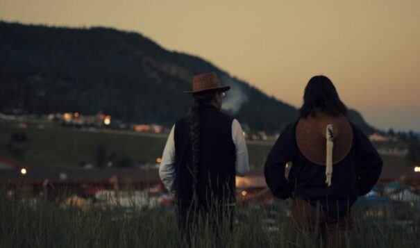 Julian Brave NoiseCat and his father Ed Archie NoiseCat look down at the Williams Lake Stampede from the top of “Indian Hill” on their roadtrip back to St. Joseph’s Mission, where Ed was born. (Credit: Emily Kassie/Sugarcane Film LLC)