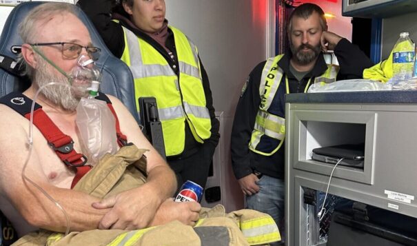 Tioga firefighter Jon Moberg receives oxygen while Cindy Hatch, a member of the Tioga EMS, and firefighter Joel Schaffett look on. Crews from Tioga were on hand to help locally with the fires while crews from outside facilities were on standby at the Tioga Medical Center. (Photo provided by Shelby Davis)